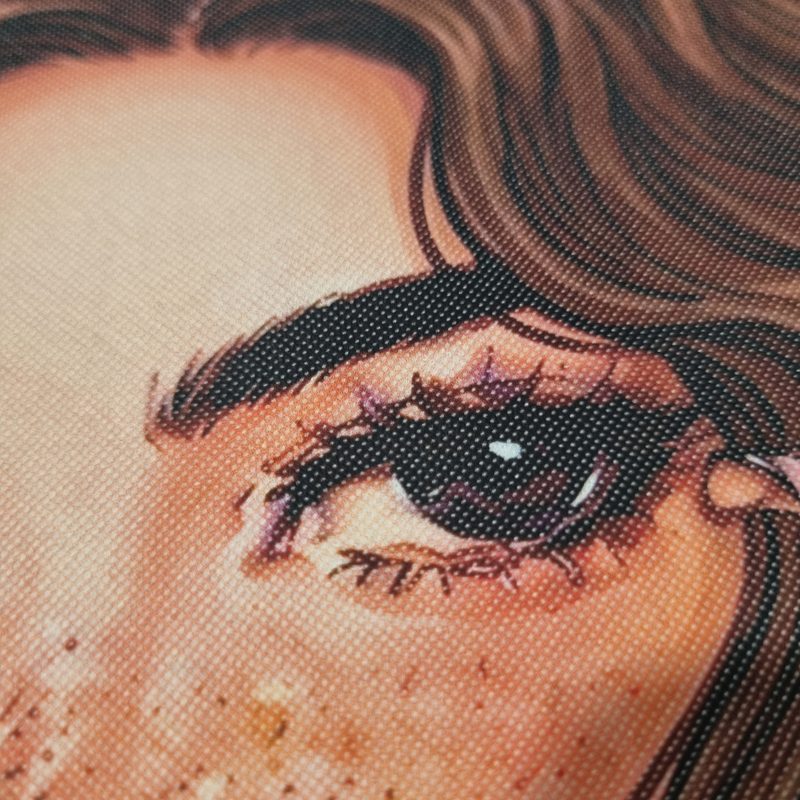 Grande plano da estampagem DTF a cores, mostrando o pormenor do olho da ilustração Muse of Chaos